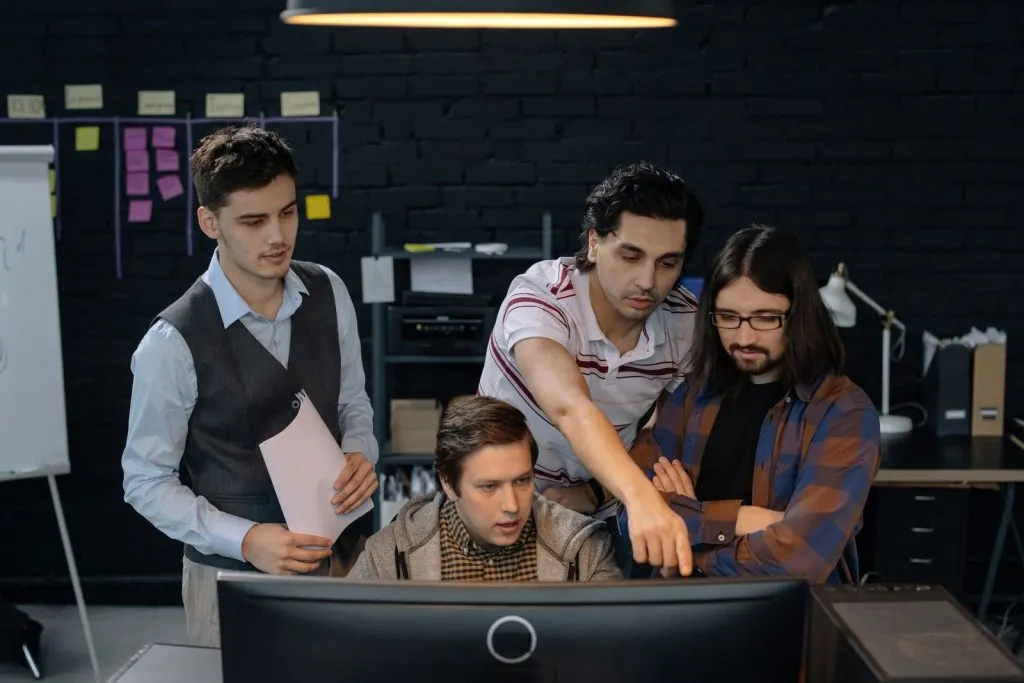 B2B technology team discussing a project at a computer