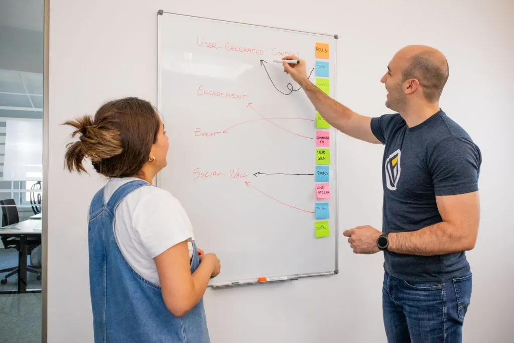Two colleagues mapping a digital transformation roadmap on a whiteboard